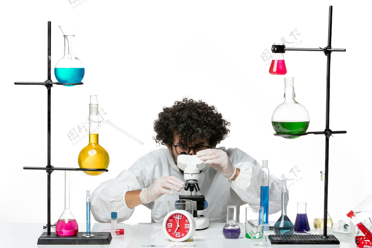 化学正面图穿着白色特别套装的年轻男科学家正在尝试使用显微镜显微镜实验罐子