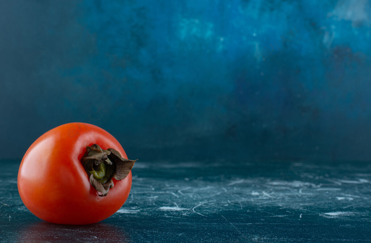 农业大理石桌上有一个新鲜的柿子有机料理成熟