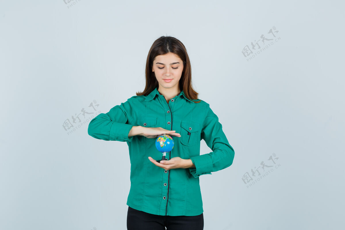 休闲穿着衬衫拿着地球仪的年轻女士 看上去很自信 正对着前方表情积极年轻