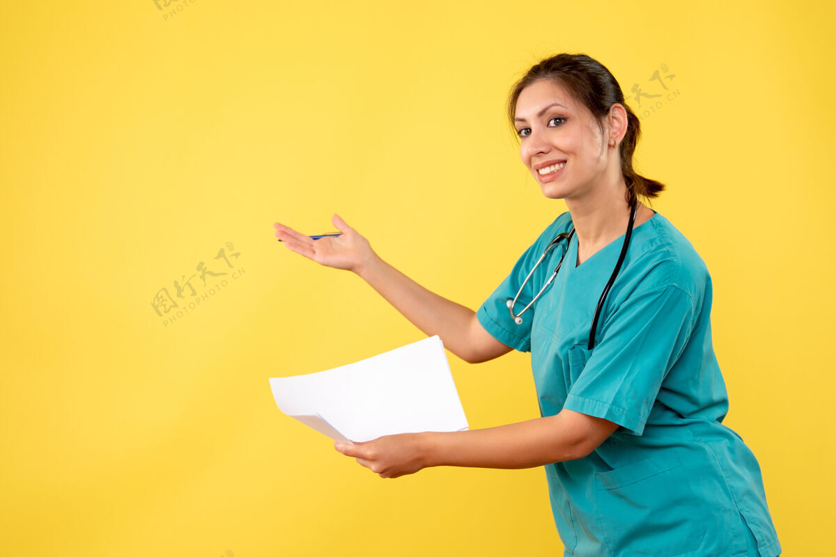 情绪正面图黄色背景下穿着医疗衫的女医生拿着纸分析女医生成人病毒