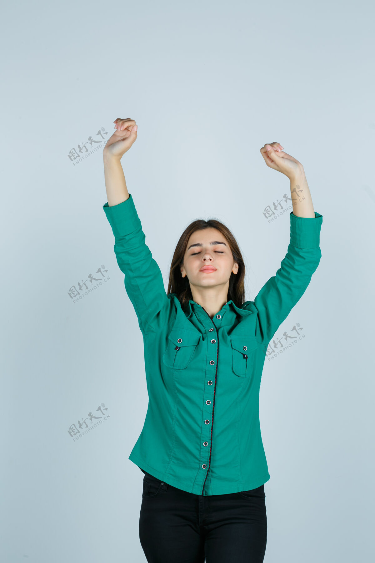 感性年轻的女选手穿着绿色衬衫 裤子 摆出获胜者的姿态 看上去很快乐 正前方的景色姿势时尚女人