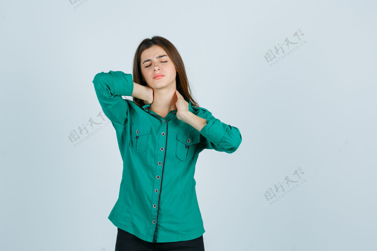 房子美丽的年轻女士感觉脖子痛在绿色衬衫和看起来不舒服 前视图疾病人手