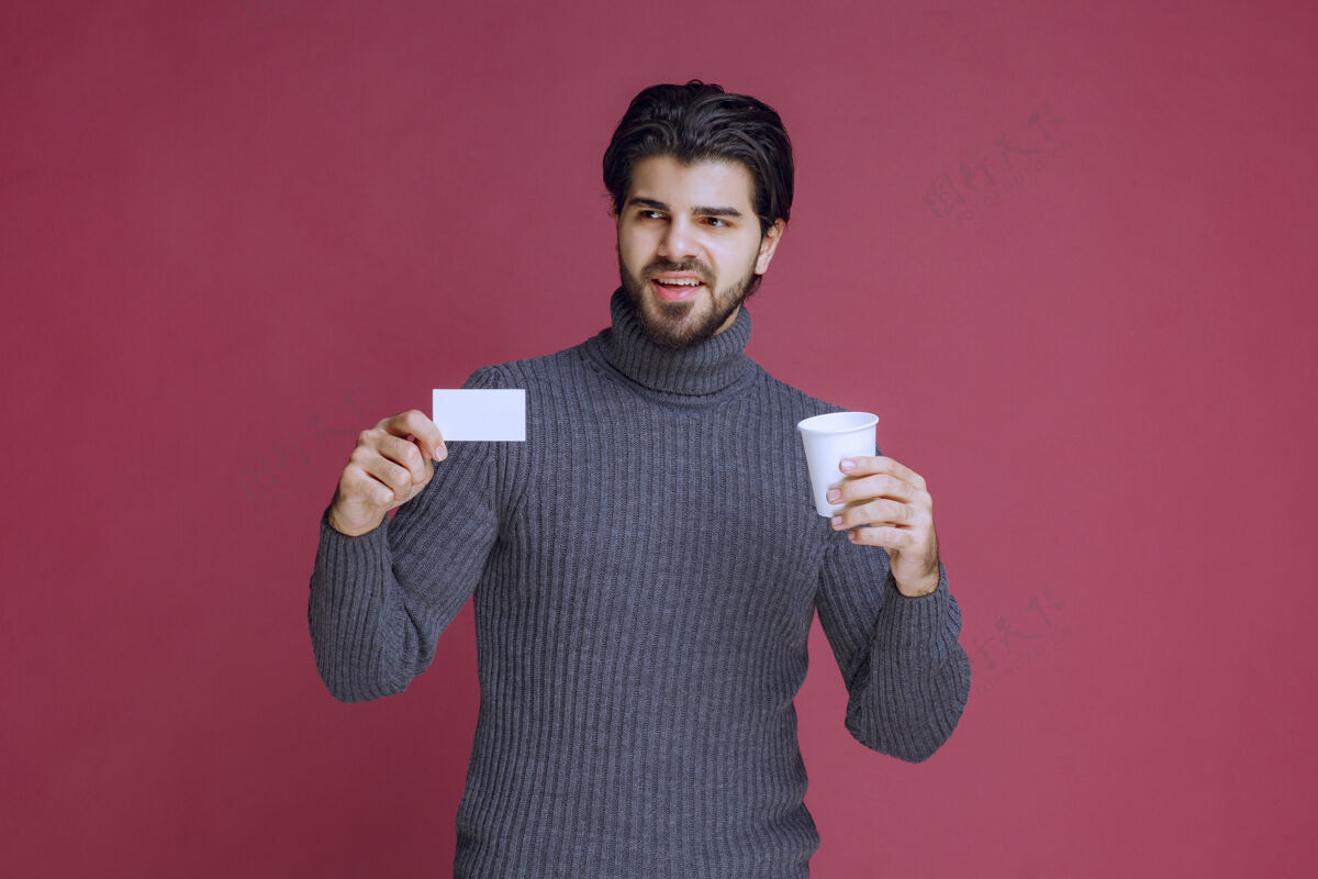 职员拿着咖啡杯展示账单或名片的男人成人休闲工人
