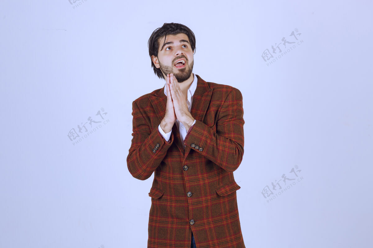 询问穿棕色外套的人双手合十祈祷照片促销成人