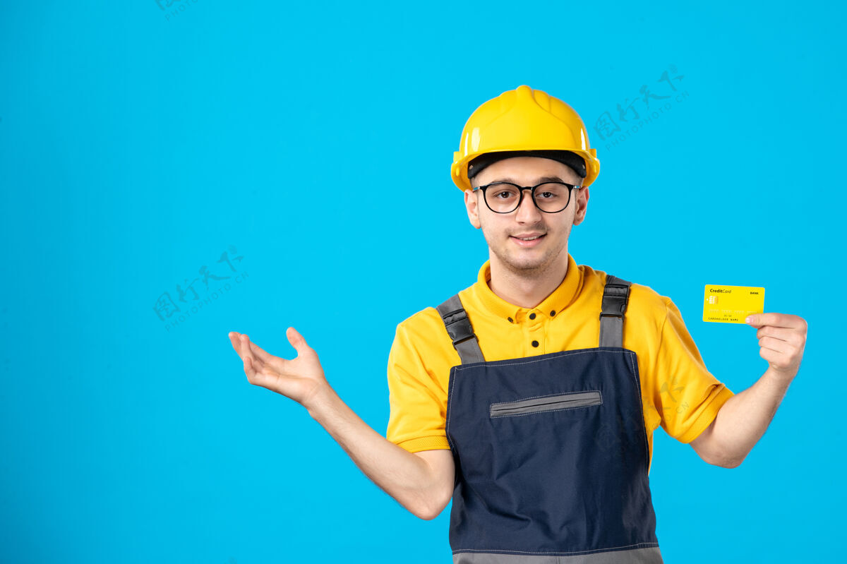 承包商身穿黄色制服 信用卡在蓝色上的男工人的正面视图服务工程师建筑师