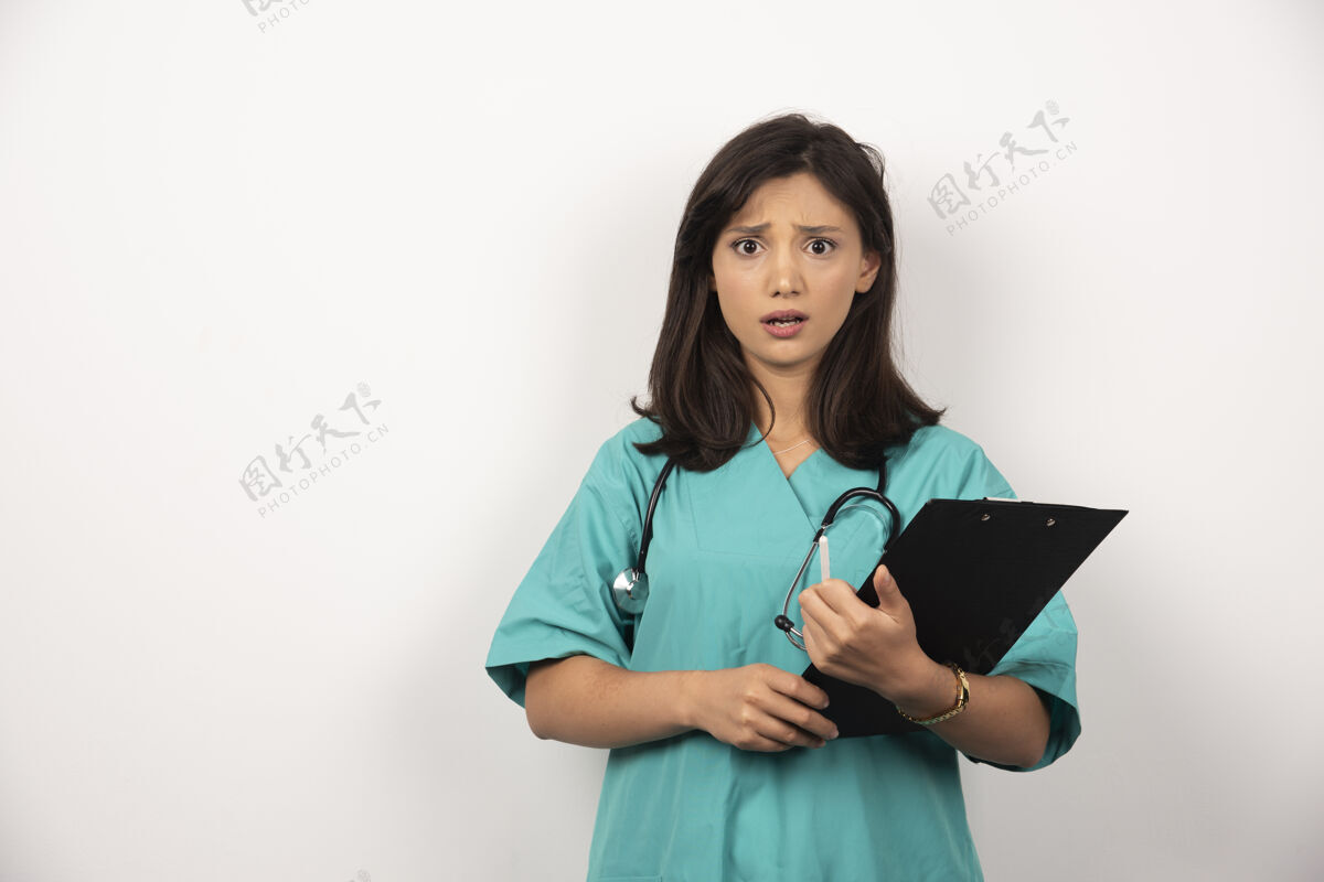 保健女医生用听诊器拿着白色背景的剪贴板持有女性医疗