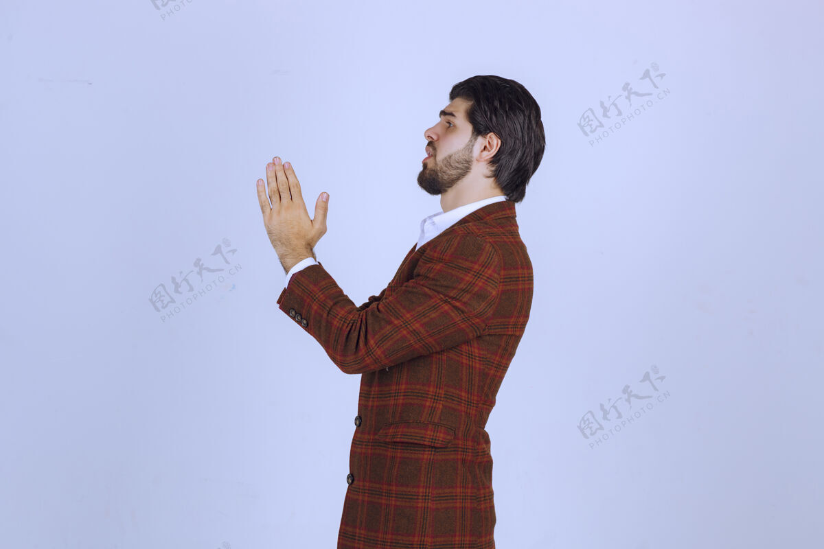 精神穿棕色外套的人双手合十祈祷年轻人年轻职员
