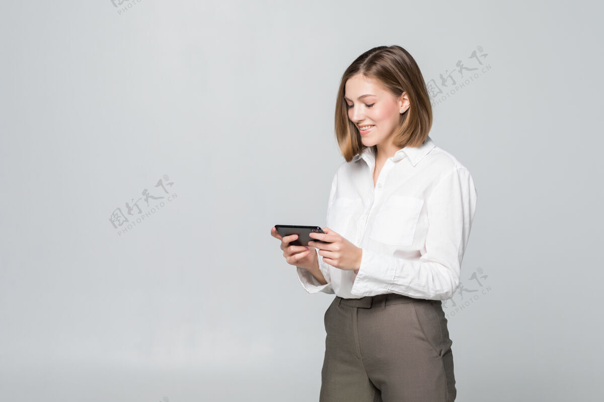 欢呼在白墙上用智能手机应用程序的女商人公司人商务女性