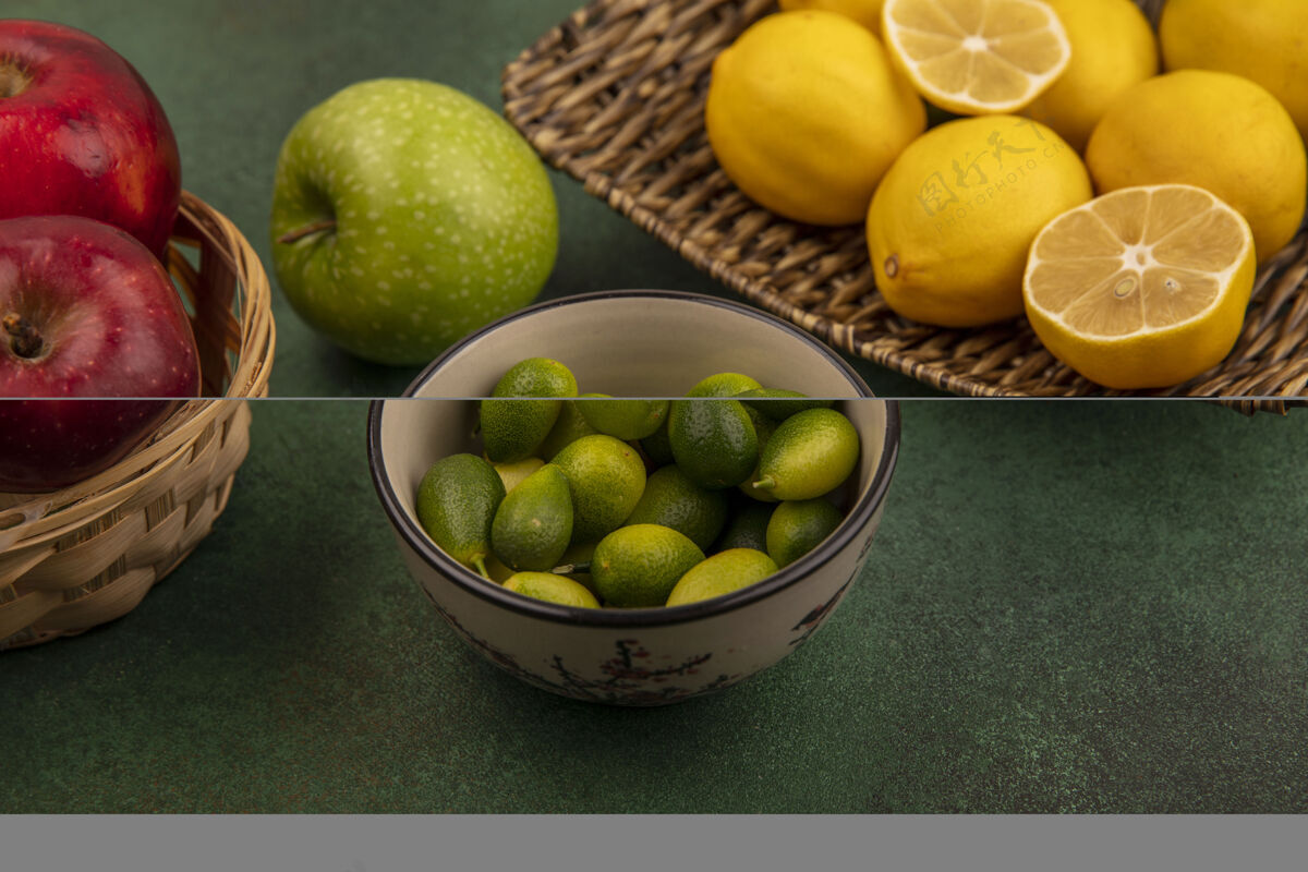 柑橘柳条托盘上酸味柠檬的俯视图 碗上放着金盏花 绿色表面的桶上放着红甜苹果饮食柠檬片