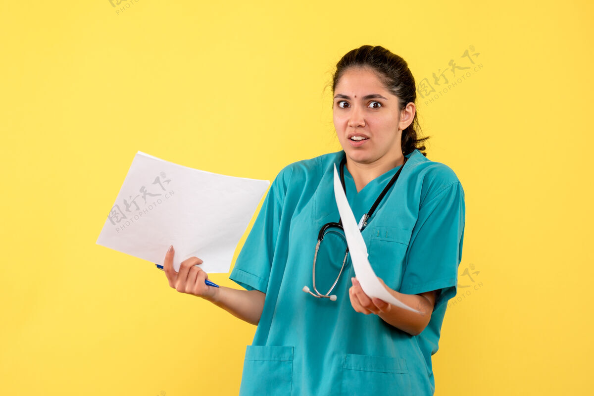 医学前视图穿着制服的女医生拿着黄色背景的文件制服诊所奇迹