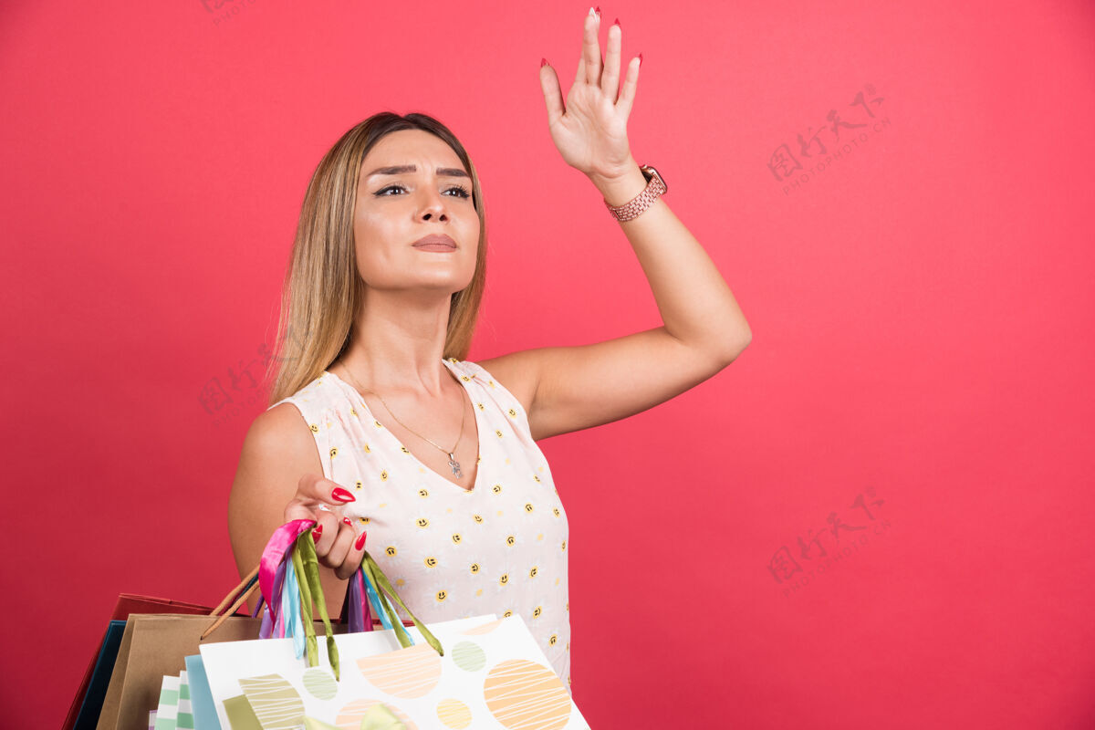 携带一个女人背着购物袋 抬头看红墙购物狂包女孩