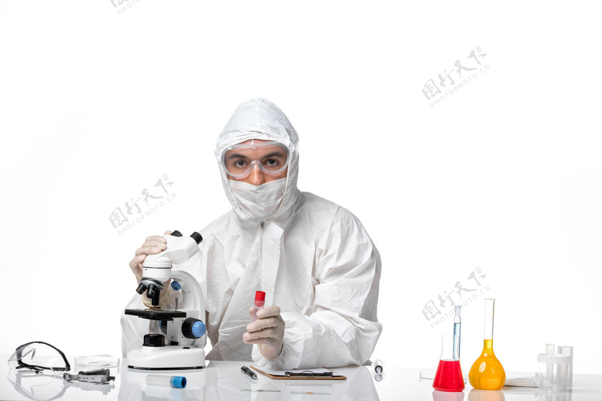 到期正面图：男医生穿着防护服 戴着面具 因为科维德在空白处使用显微镜医学显微镜男医生
