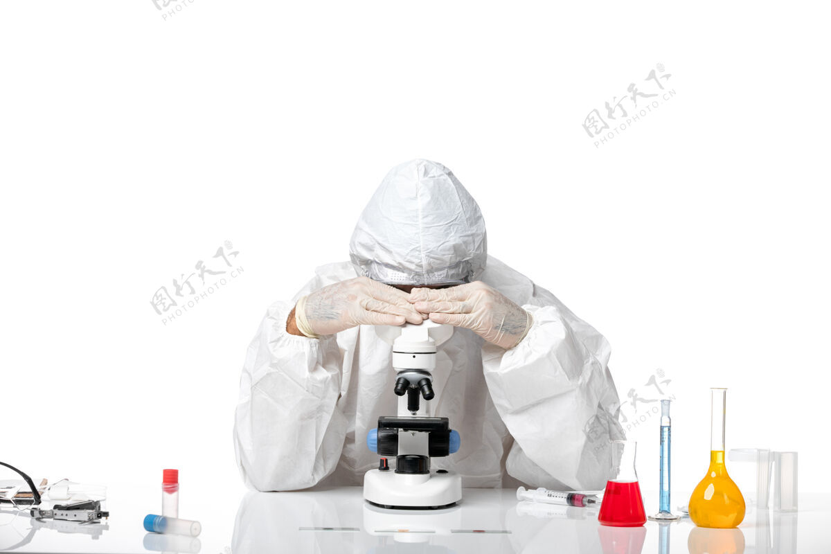 病毒前视图男医生穿着防护服 戴着面罩 在空白处使用显微镜科学男医生医学