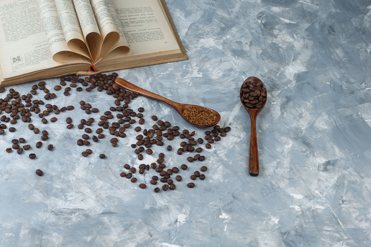 杯子咖啡豆 速溶咖啡在一个木制勺子上 书特写在浅蓝色大理石背景上香味味道豆子