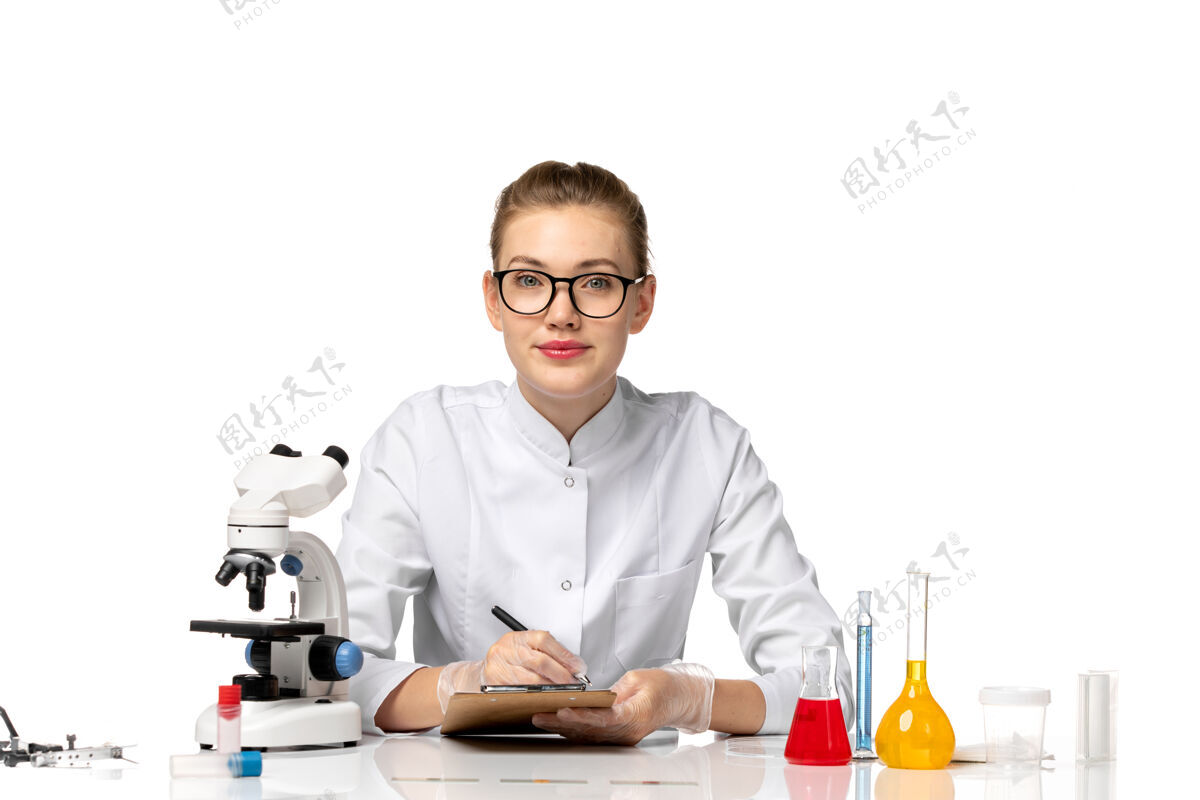 流行病前视图穿着白色医疗服的女医生在白色办公桌上处理解决方案病毒专业人员女医生