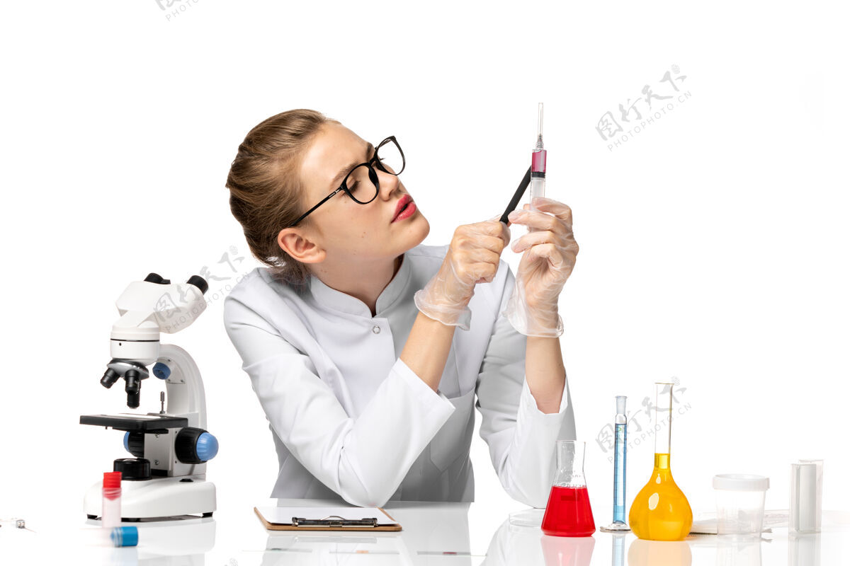 秘书前视图：穿着白色医疗服的女医生在浅白的空间里拿着针剂病毒注射正面
