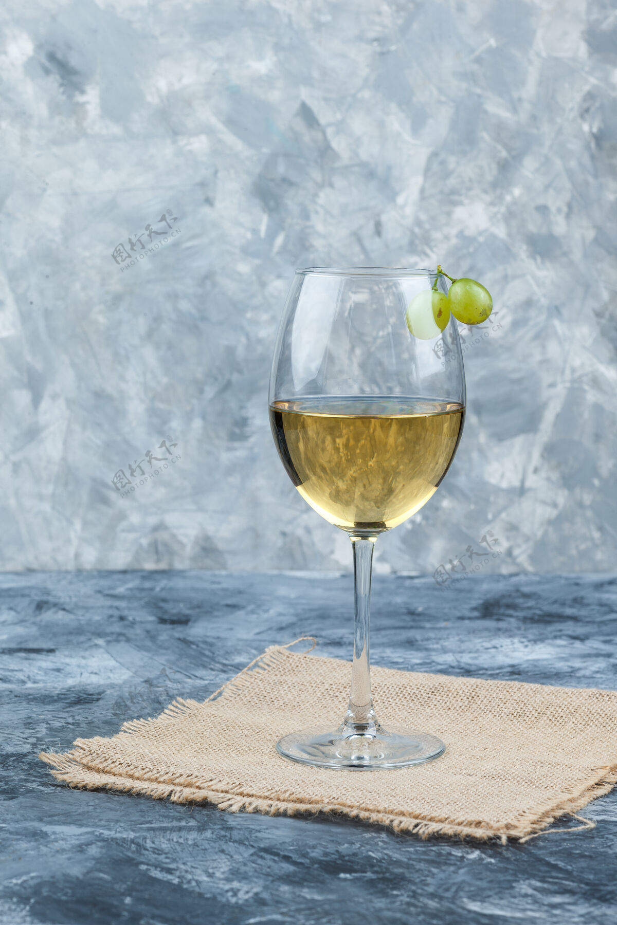 晚餐侧视图新鲜葡萄酒在玻璃上与葡萄石膏和一块布袋背景垂直麻袋新鲜酒精