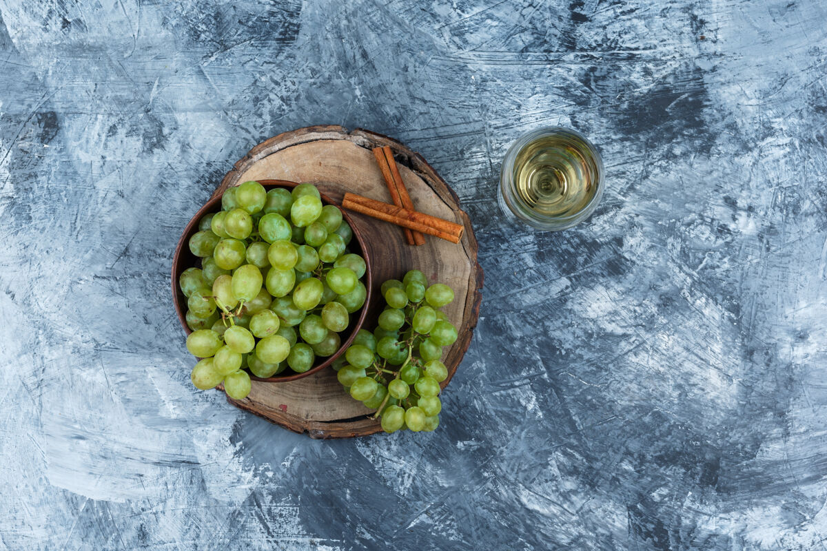 有机白葡萄 肉桂放在木板上 一杯威士忌在深蓝色大理石背景上俯瞰美味葡萄酒饮食