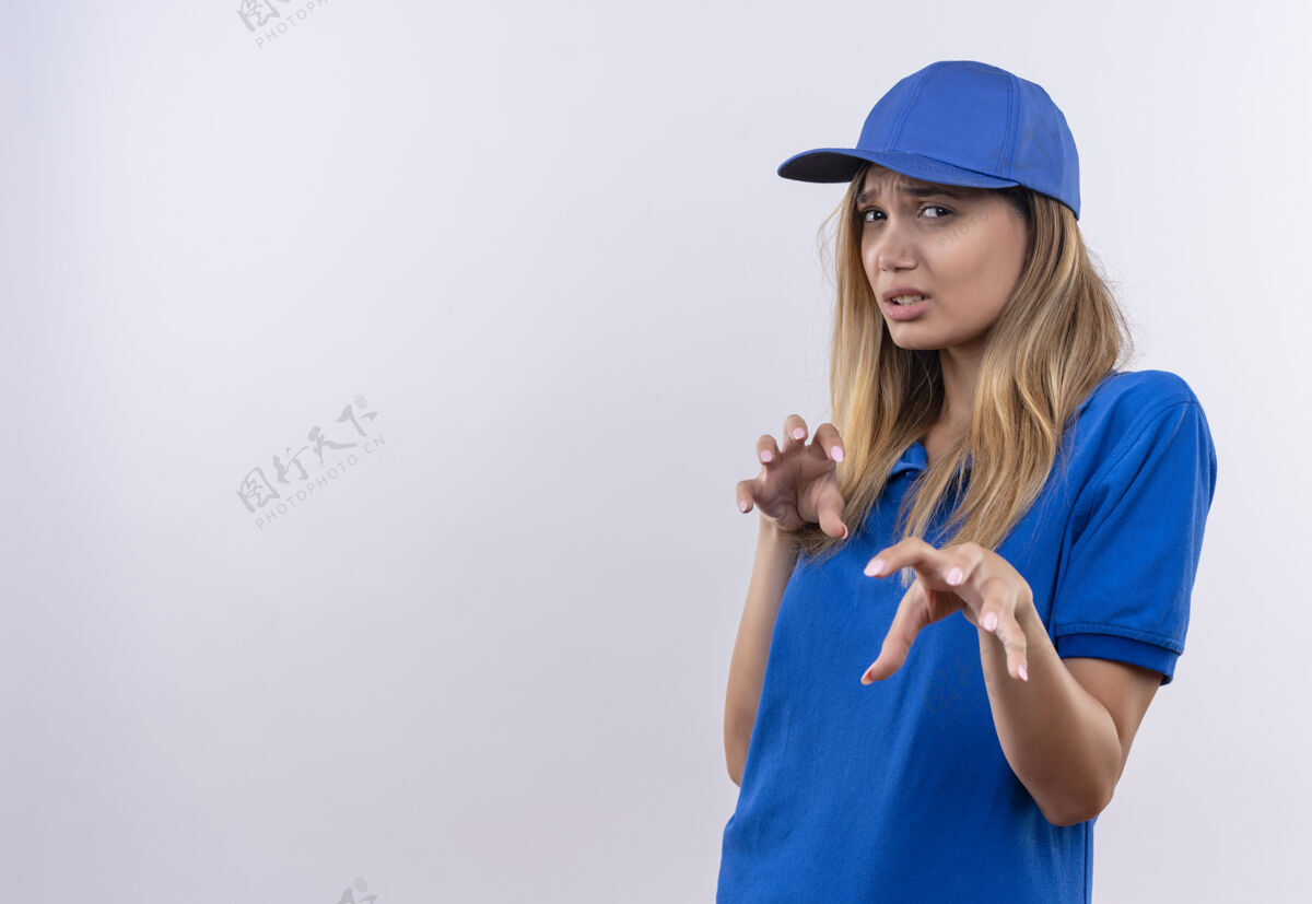 手势年轻的女送货员穿着蓝色制服和帽子显示老虎的姿态显示帽子制服