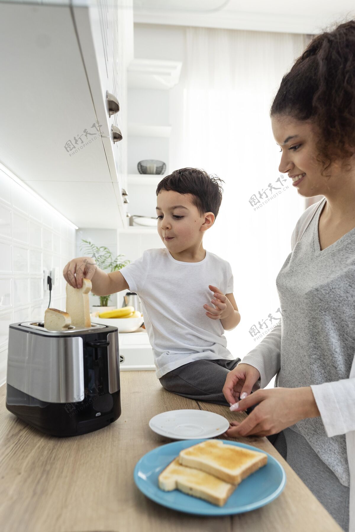 快乐的家庭快乐的黑人孩子帮他妈妈吃早餐人黑人关系