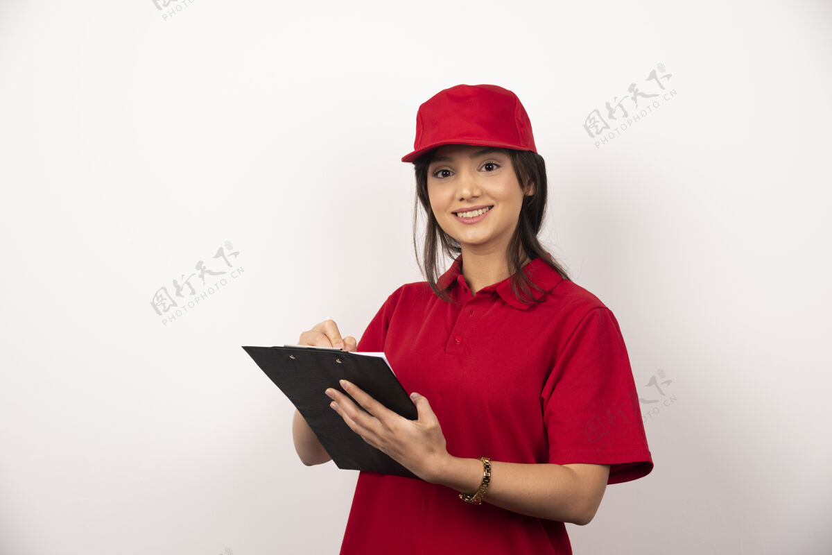 递送穿着红色制服的年轻女送货员 白色背景上有剪贴板年轻人帽子工人