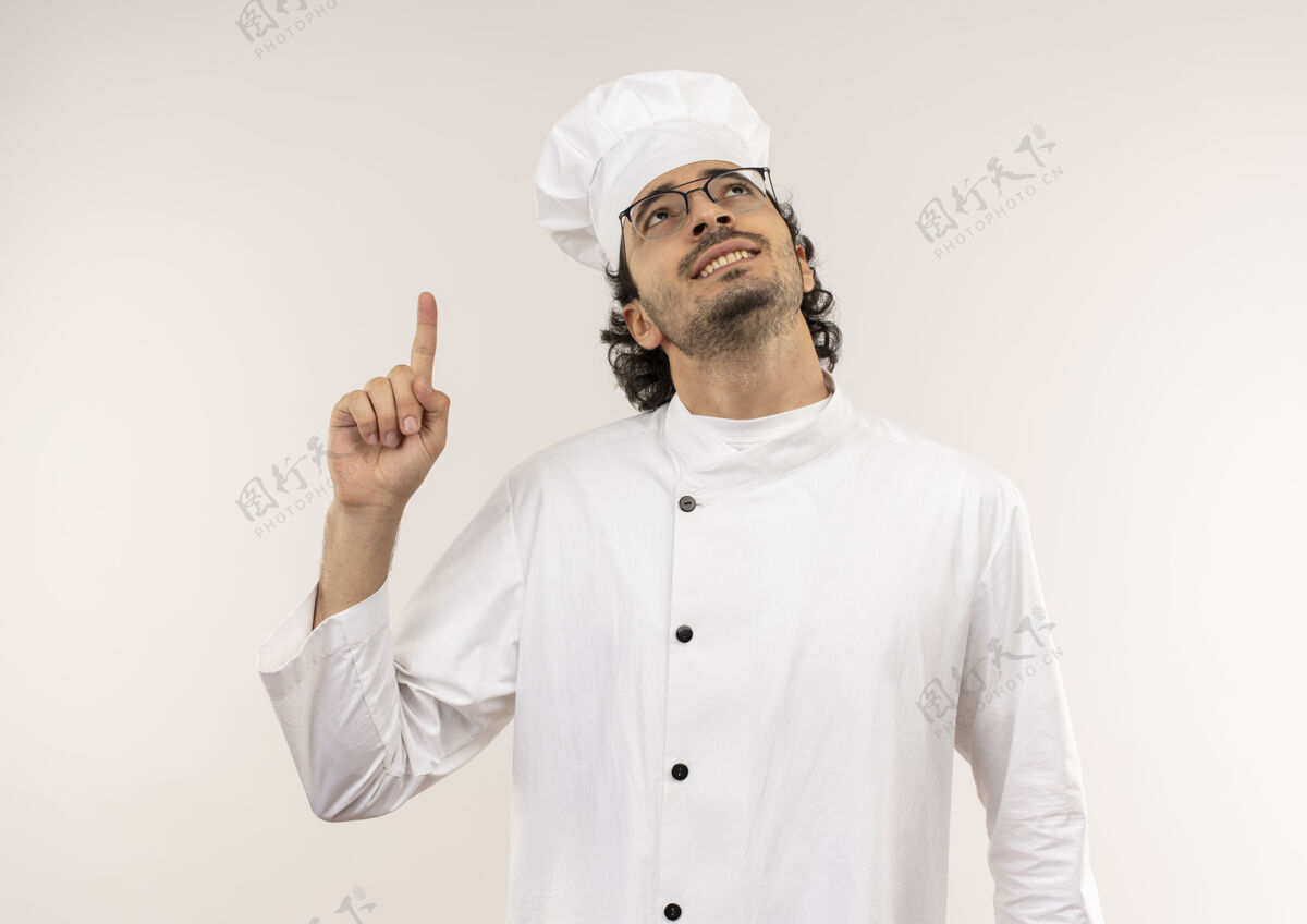 向上看着面带微笑的年轻男厨师穿着厨师制服 戴着眼镜指向一旁壁板微笑点