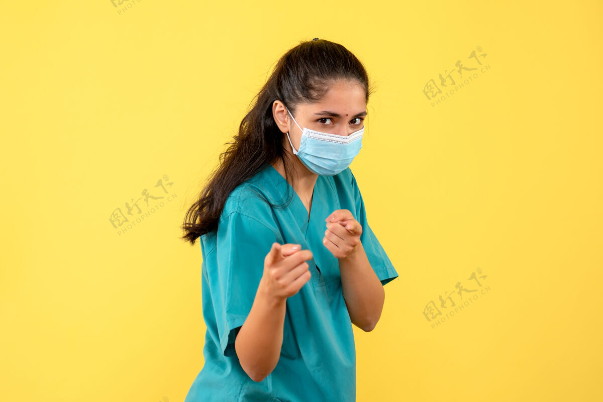 脸黄色墙壁上 美丽的女医生正前方带着医用面罩听诊器微笑人