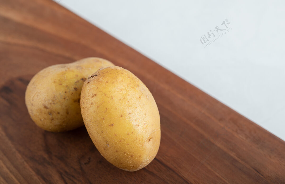 健康棕色木板上两个新鲜土豆的特写照片耕作生的自然