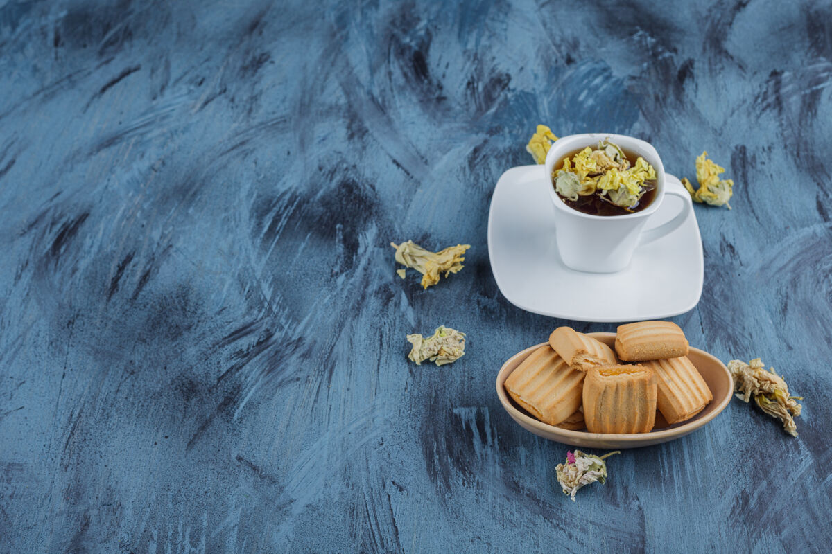 糕点美味的饼干和一杯凉茶在蓝色的表面上美味好吃营养