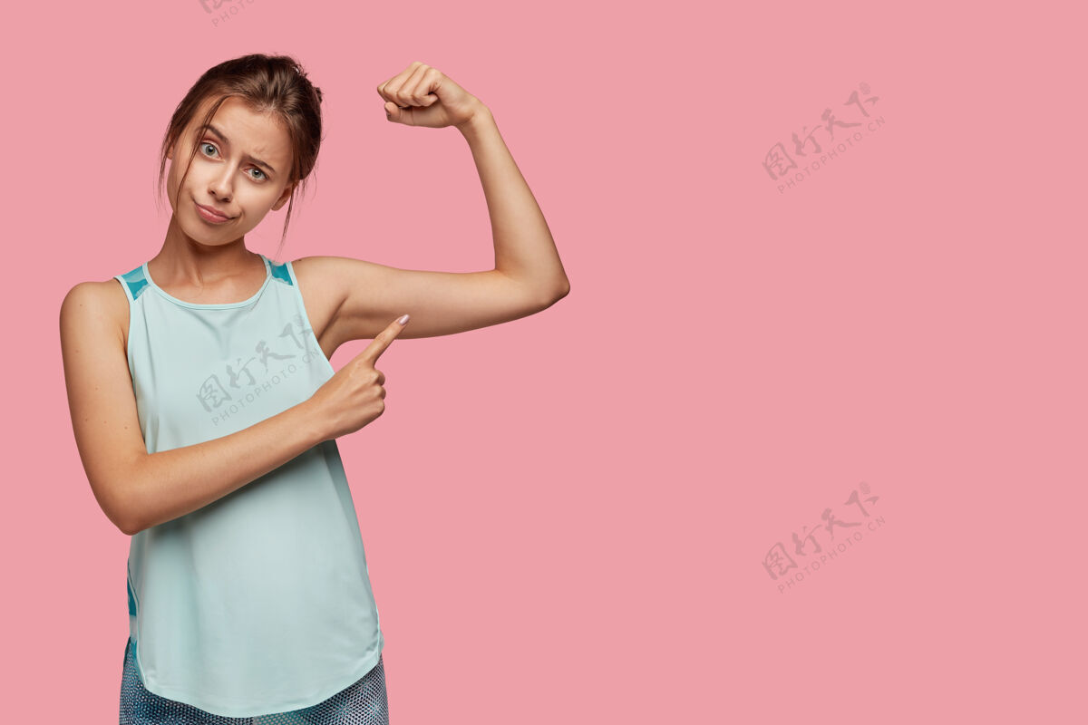 力量健康的生活方式和运动理念不满意的欧洲女人指向手臂肌肉强壮欧洲指向