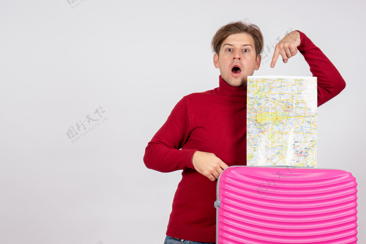 孩子男性游客的正面图 白色墙上有地图和粉红色的包地图包夏天