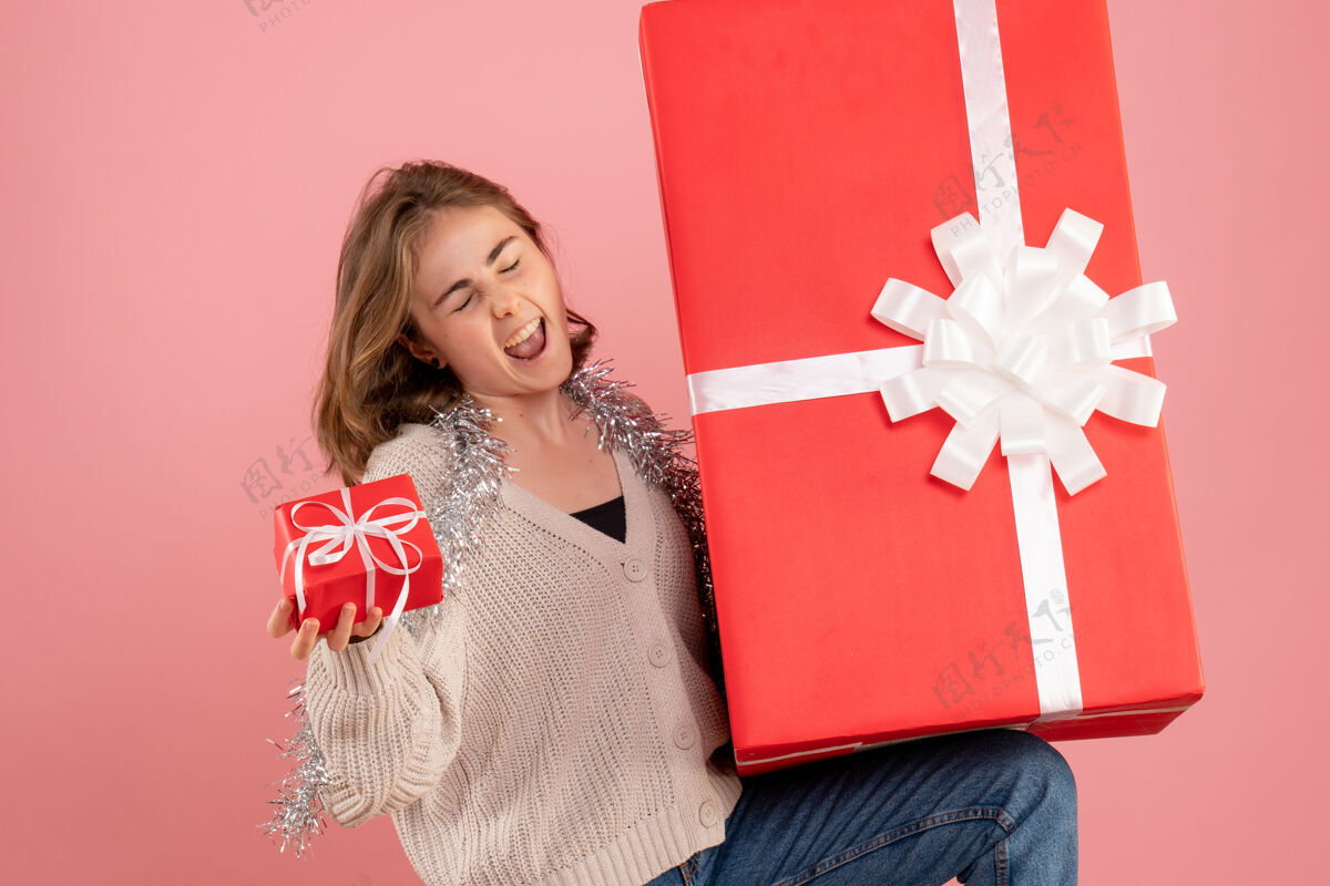 盒子年轻的女性拿着粉红色的圣诞礼物盒手持礼物女士