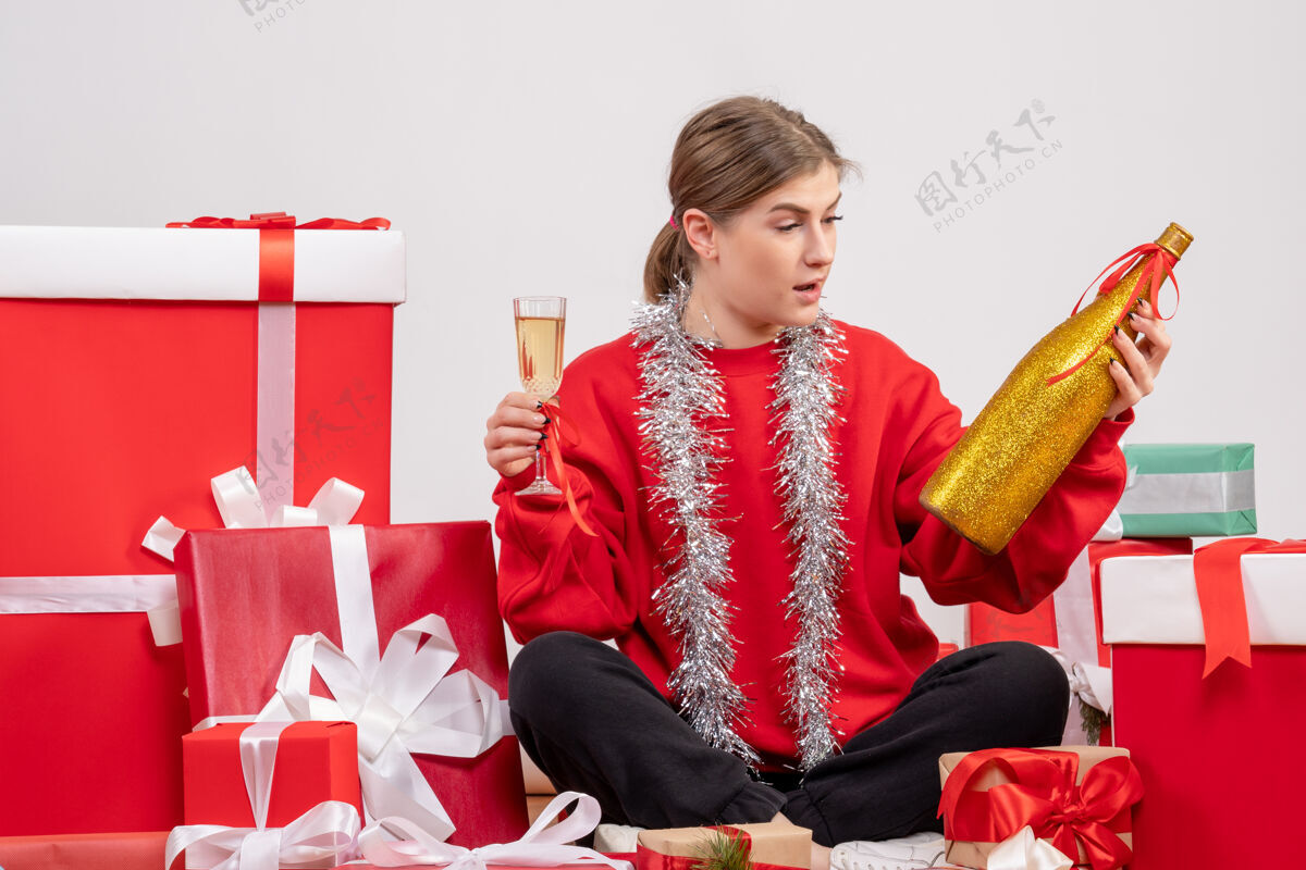礼物漂亮的女人围坐在圣诞礼物旁 用白色香槟庆祝坐着香槟漂亮的女人