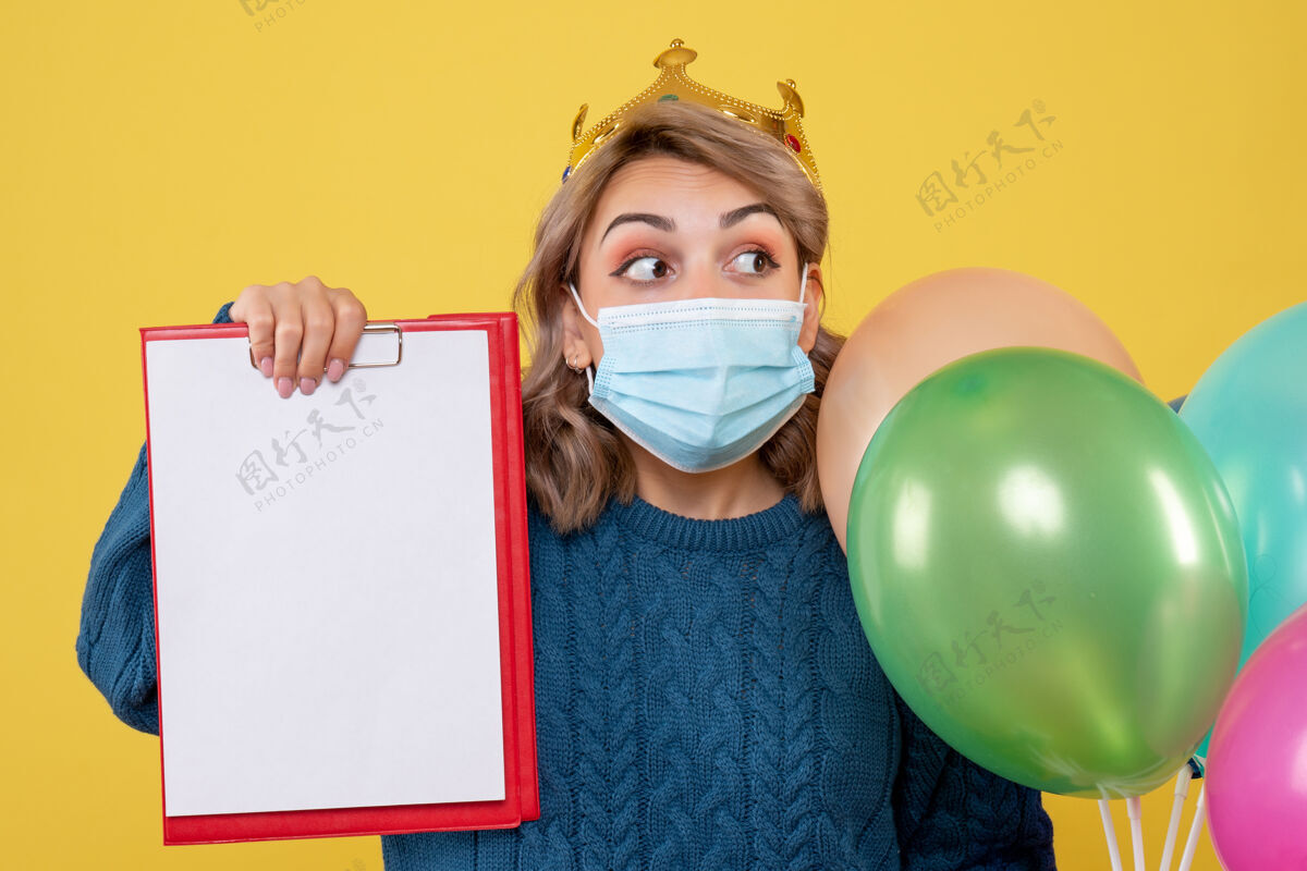 情绪年轻的女性拿着黄色的无菌面具气球举行医生看法