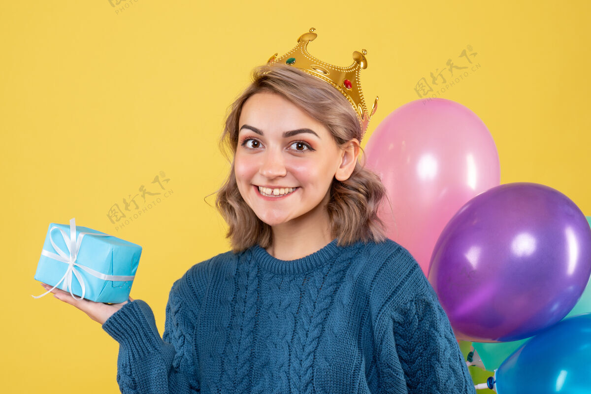 聚会年轻的女性拿着气球和黄色的小礼物情感观点礼物