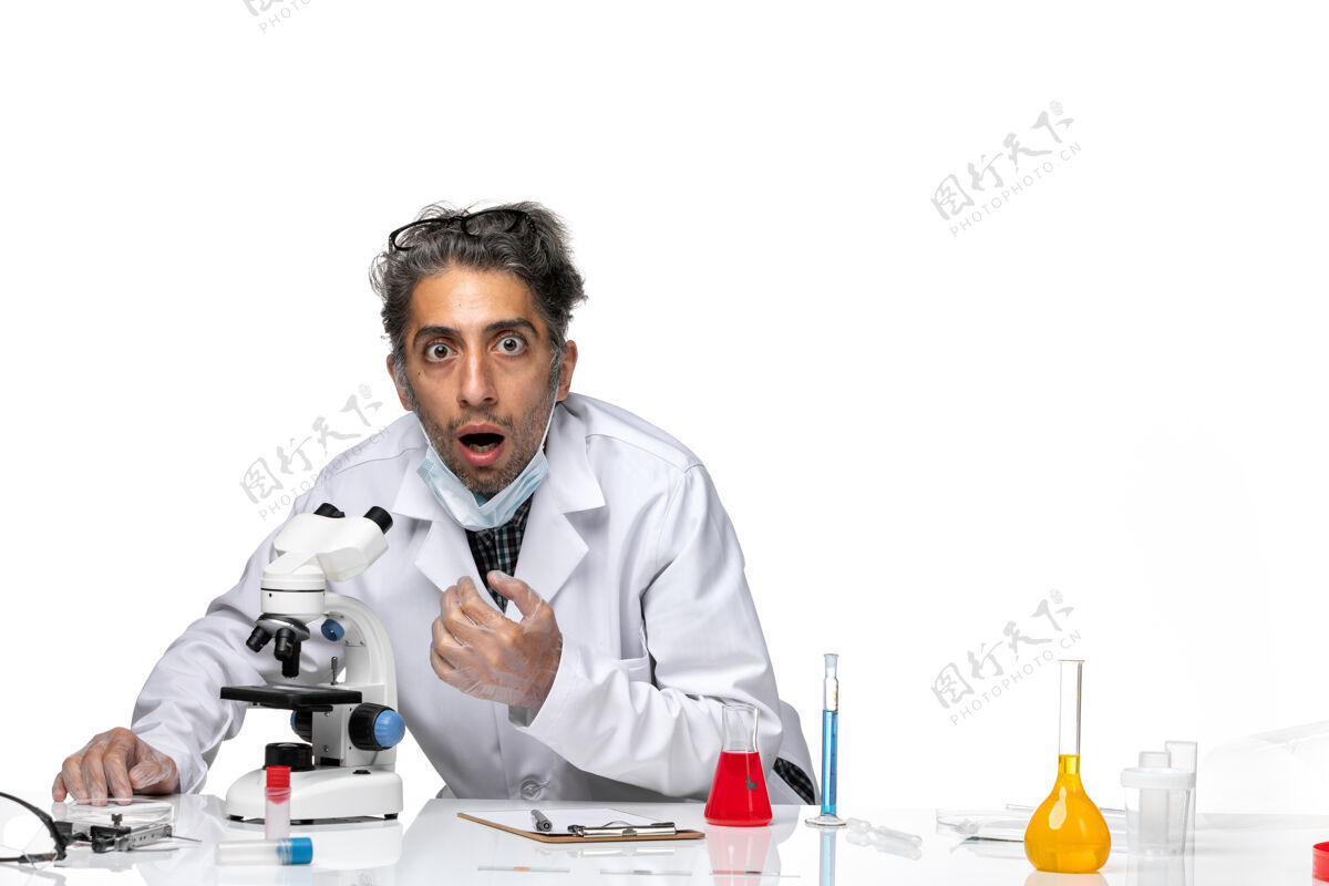 实验室前视图中年科学家穿着特殊的白色西装使用显微镜病毒显微镜正面