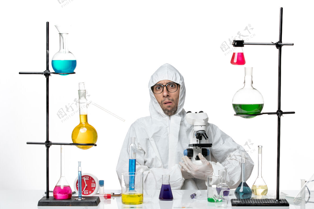保护正面图穿着特殊防护服手持显微镜的男科学家实验室人外套