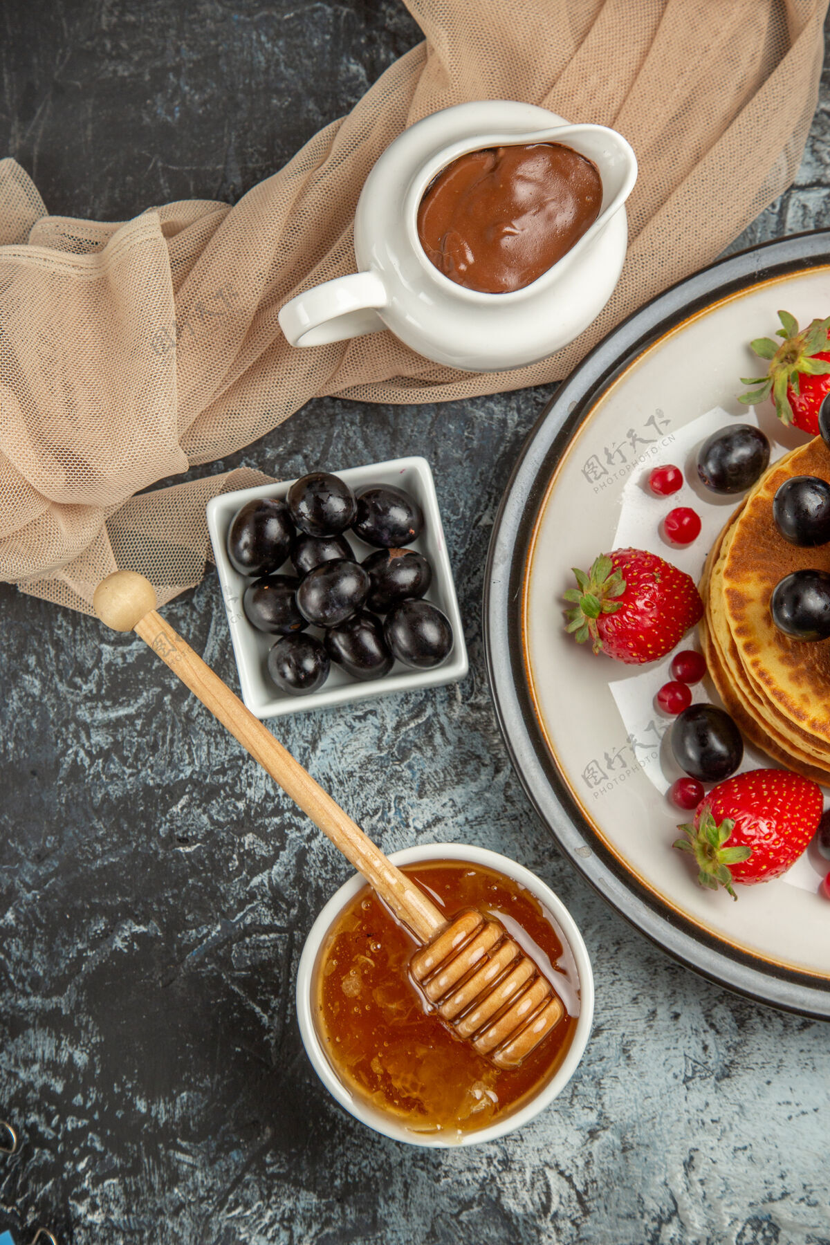 桌子俯瞰美味的薄饼与水果和蜂蜜在一个轻表面甜水果蛋糕蛋糕顶部早餐