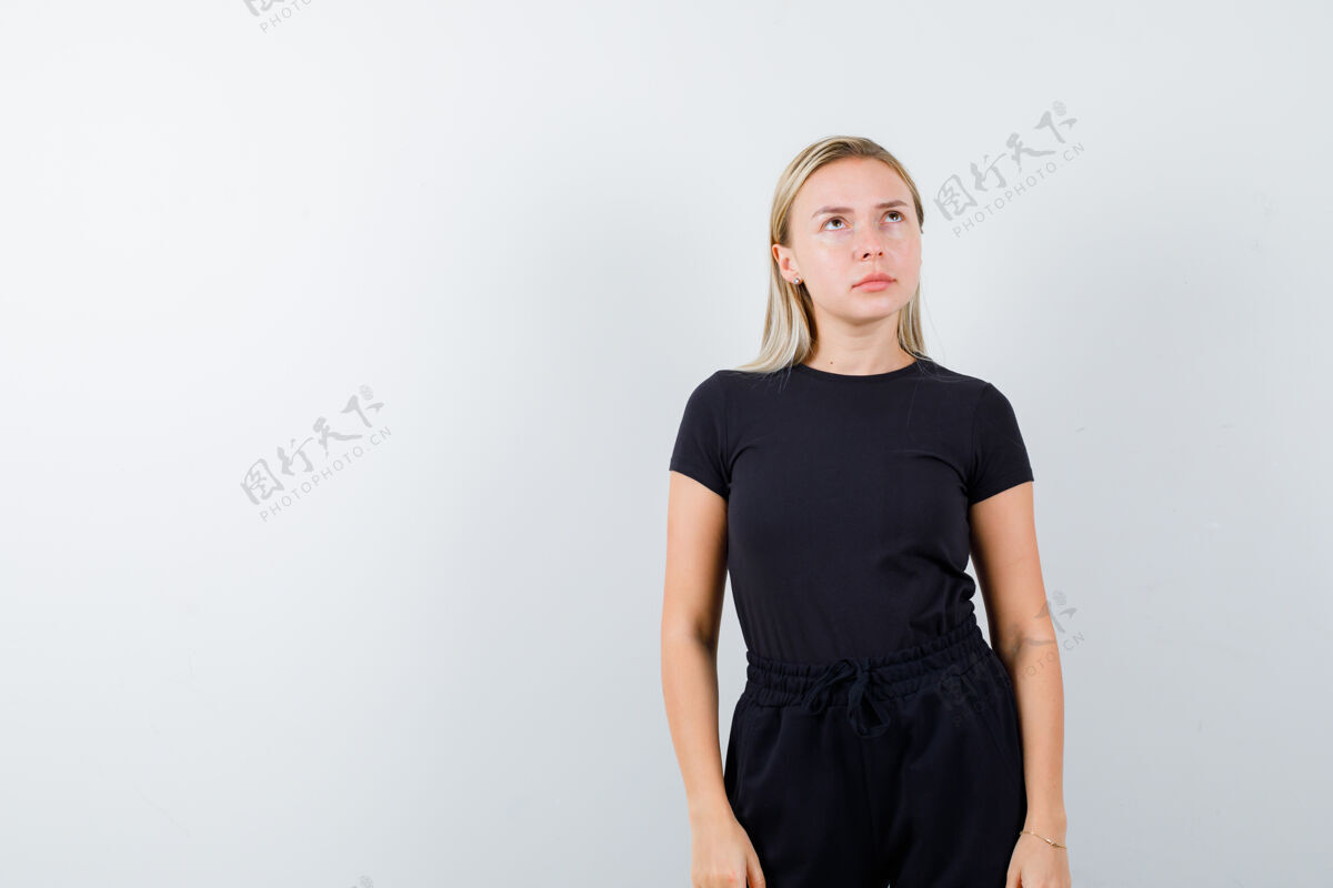 头发年轻女士穿着t恤 裤子摆出思考的姿势 看上去很忧郁正面图快乐女士人