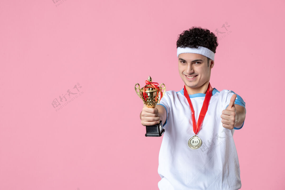金色正面图身穿运动服的年轻球员 粉色墙上挂着金杯体育成功粉红色
