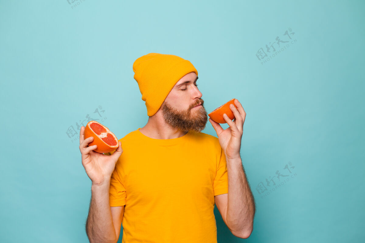 水疗留着胡子的欧洲男人穿着黄色衬衫 闭着眼睛闻着美味的柚子果汁纯净男人