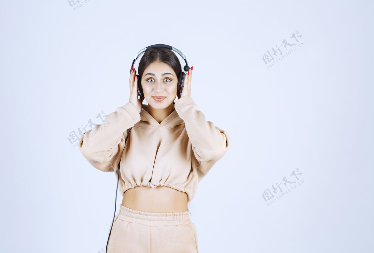 工人年轻女子戴着耳机 愉快地听着她的播放列表聪明女人人