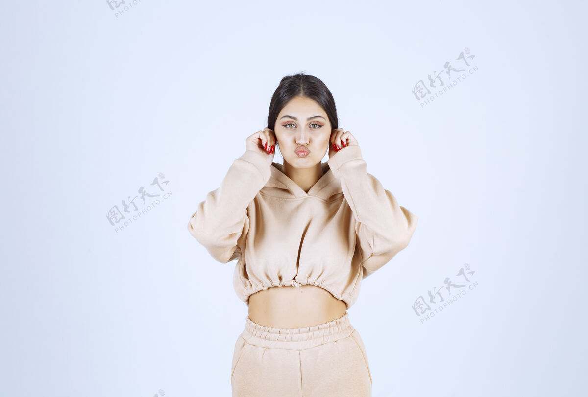 女性一个年轻女人拉着耳朵表示迷信人类模特聪明