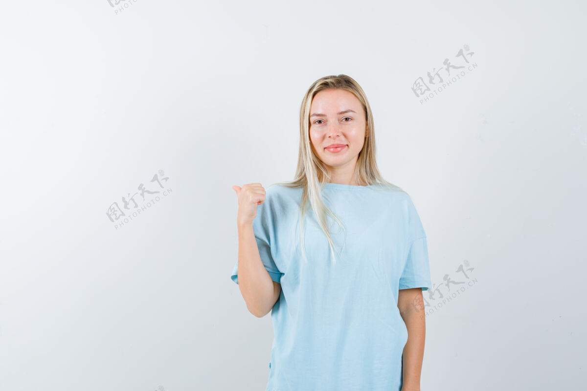 漂亮穿着t恤的年轻女士用大拇指指着后面 看起来很自信 正面视图皮肤皮肤护理头部
