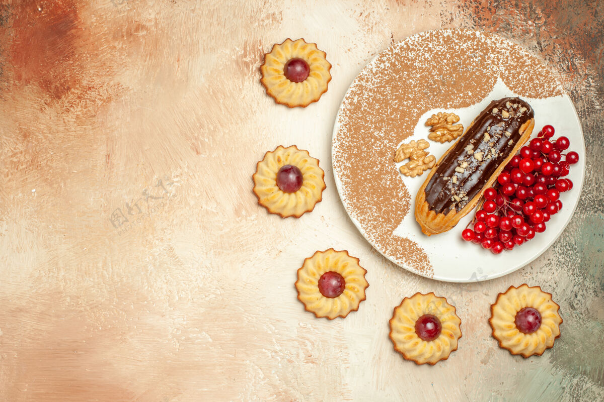 饼干俯瞰美味的eclair 配上红色浆果和饼干 甜点甜甜红色顶部脏的