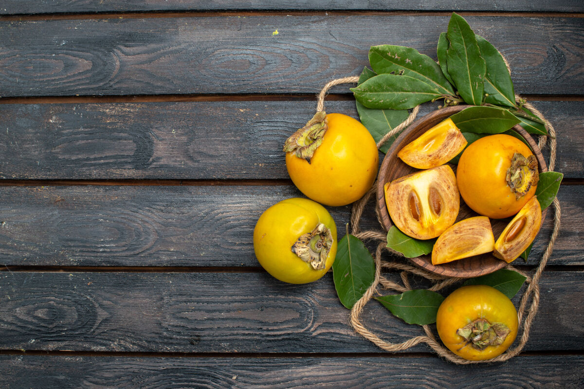 柑橘在木质质朴的餐桌上俯瞰新鲜甜甜的柿子 品尝成熟的水果味道黄色乡村