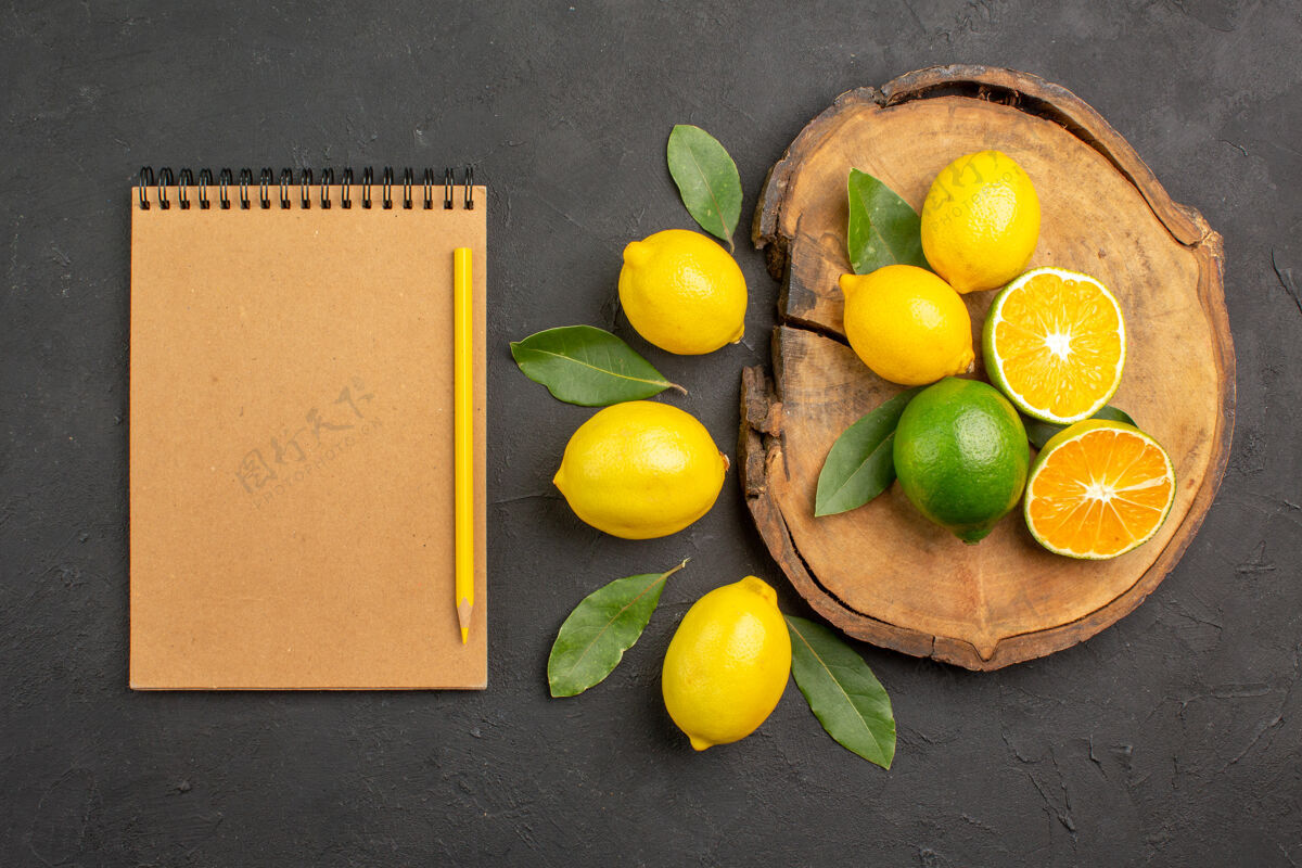 酸橙顶上看新鲜的酸柠檬和叶子放在一张深色的桌子上黄色的水果莱姆柑橘顶部健康水果