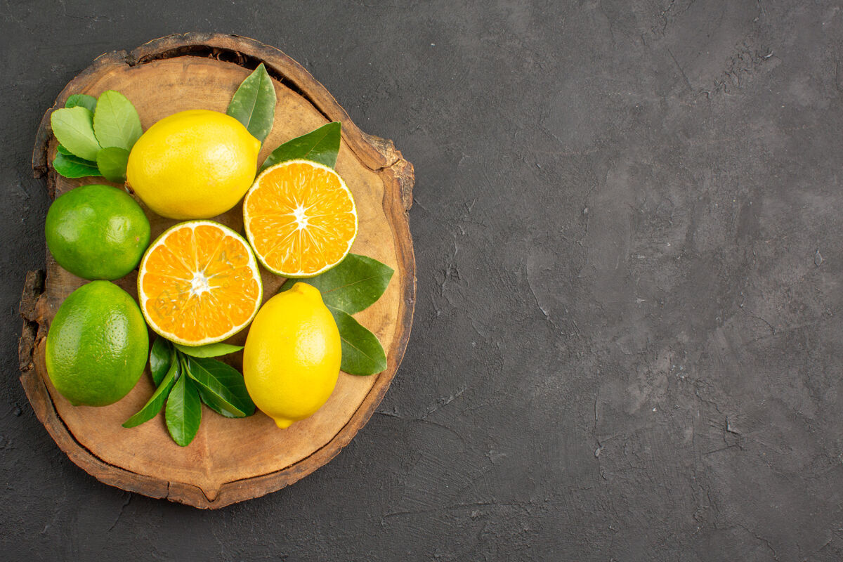 酸橙在一张深色的桌子上俯瞰新鲜的酸柠檬 柑橘和酸橙水果水果健康深色