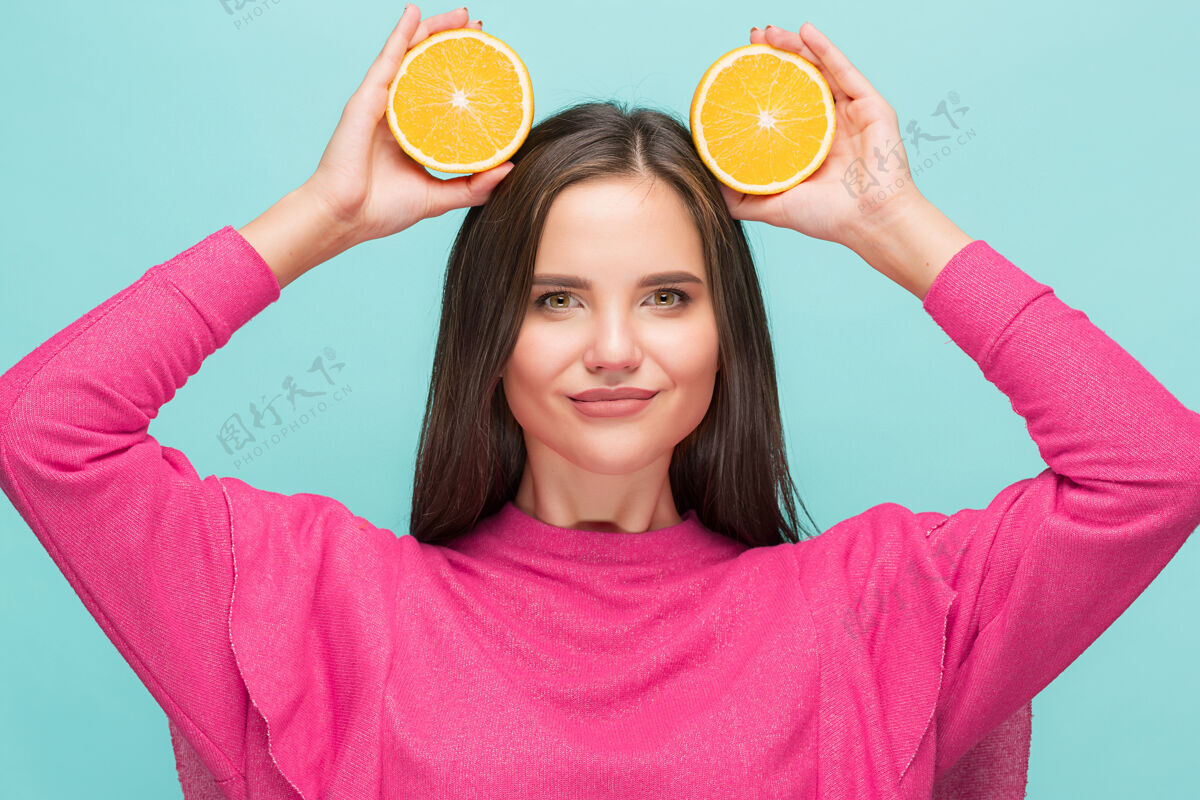 橙色漂亮女人的脸上有美味的橘子明亮食物成人