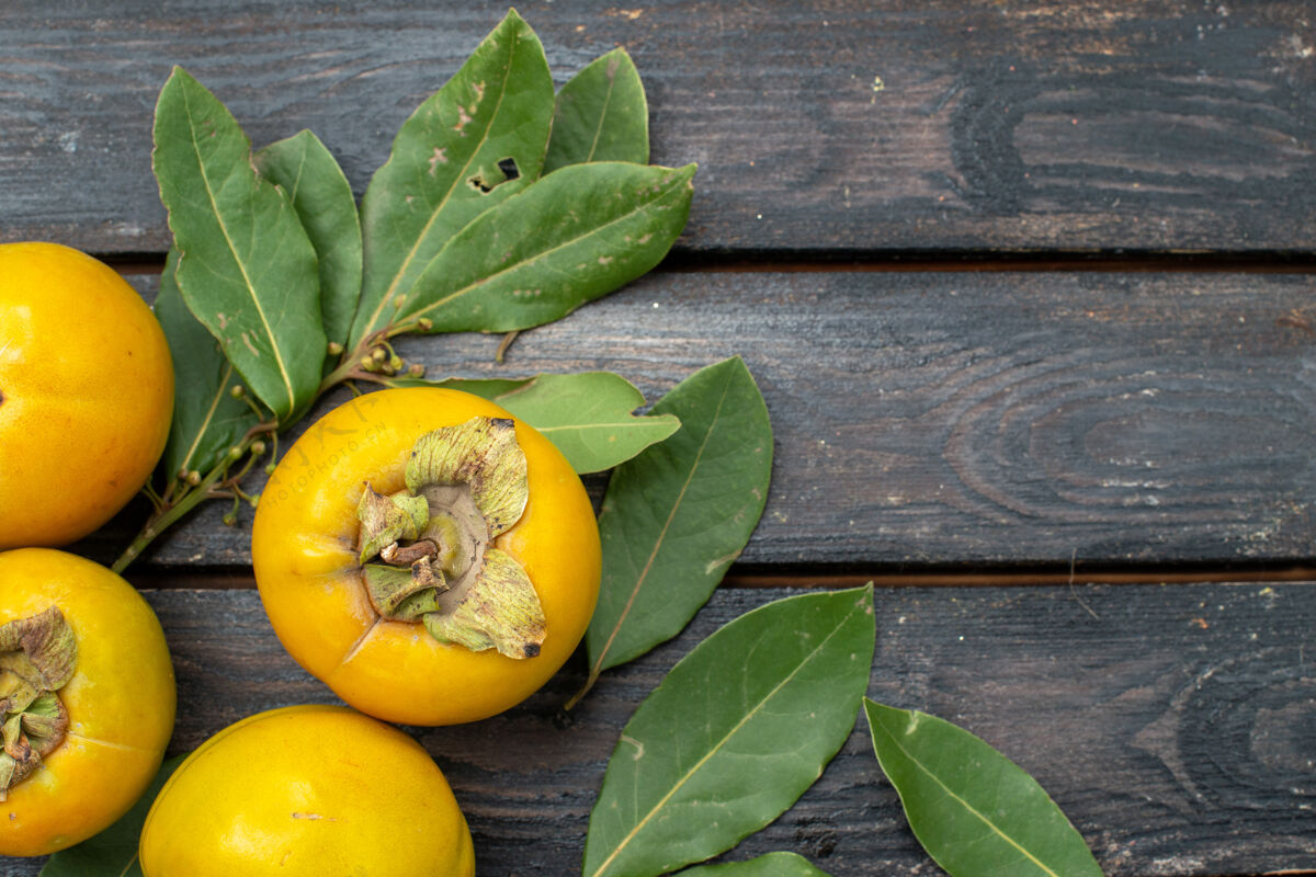 木材顶视图新鲜的柿子放在木质质朴的餐桌上 水果醇香熟透乡村新鲜柿子健康